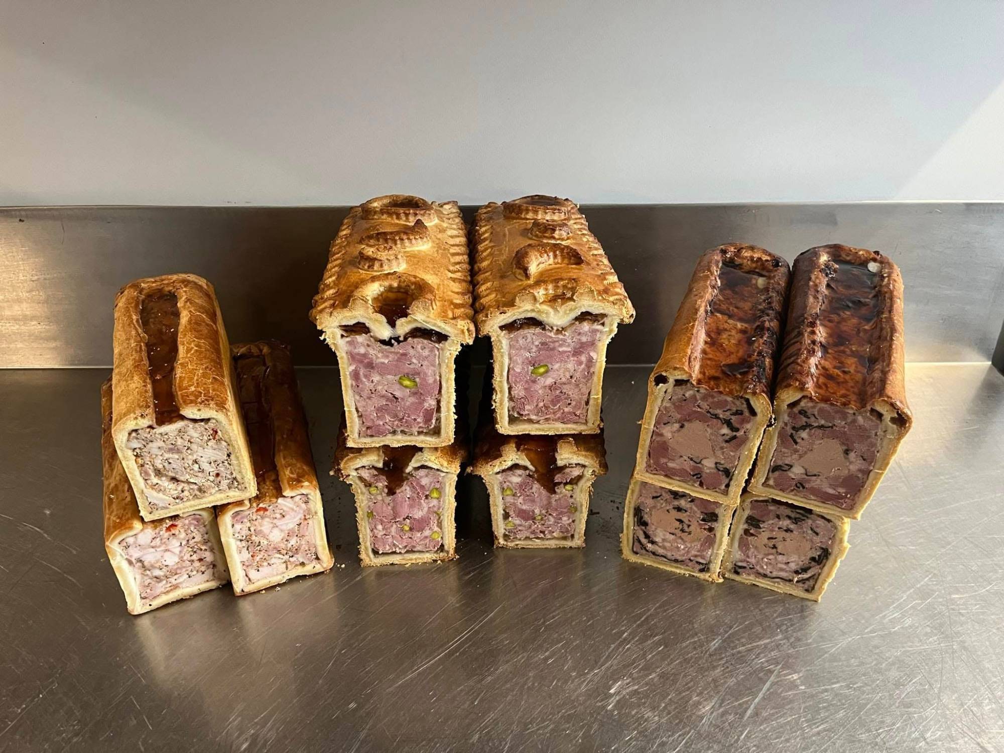 Les trois pâtés en croûte de la maison, coupés : poulet thym citron à gauche, veau de lait pistache au centre, canard trompettes à droite