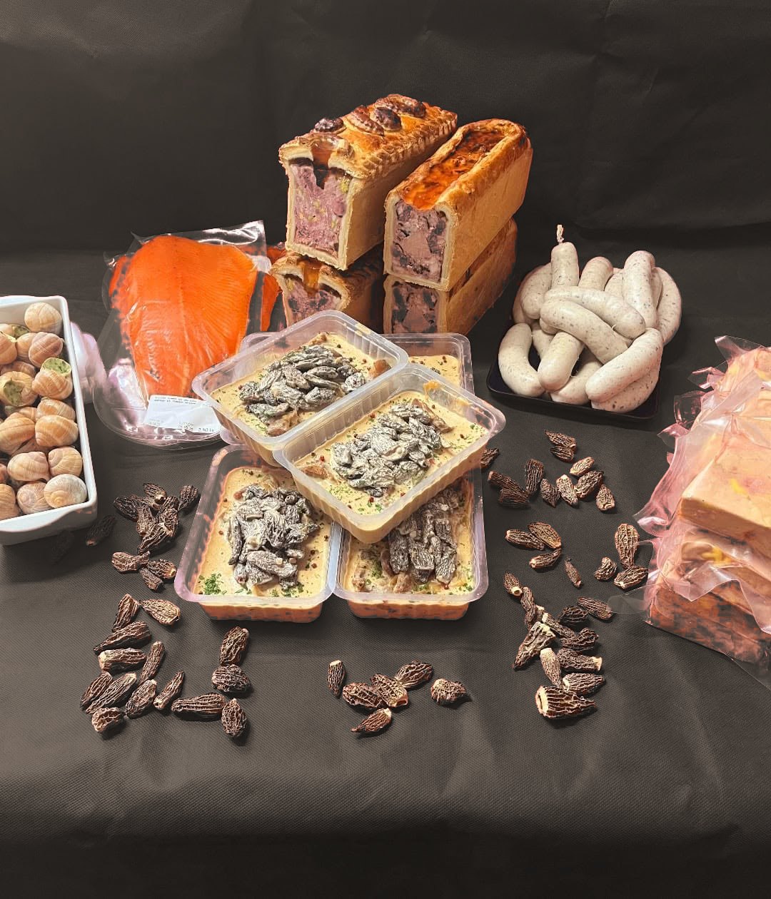 Assortiment traiteur de fête : pâtés en croûte, saumon fumé, escargots, boudins blancs et plats aux morilles